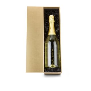 Klare Flasche mit Goldflockentraum (0,75 l) mit Druck „Gold Edition“, gebettet auf schwarzem Sizzle im goldenen Karton.