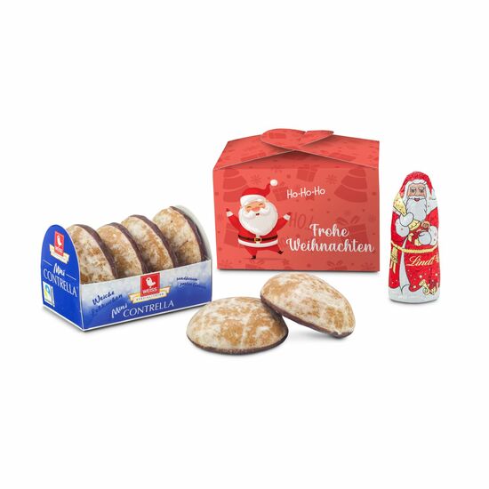 Ein glasierter Mini Lebkuchen (50 g) und Lindt Mini Nikolaus (10 g) verpackt in einer roten Schleifenverpackung mit "Frohe Weihnachten".