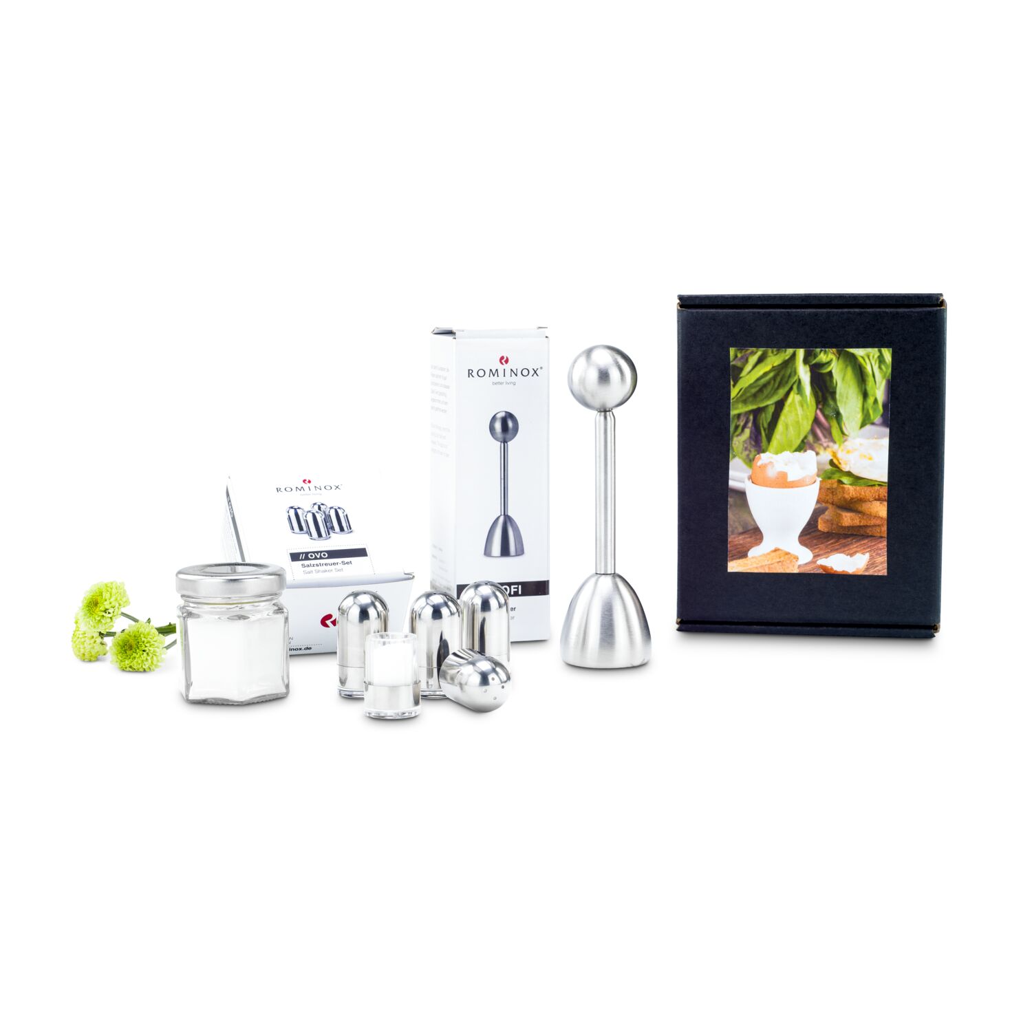 Ein Set aus vier Minisalzstreuern, einem Eierköpfer und einem Glas Meersalz. Alles kommt verpackt in einer schwarzen Geschenkbox mit Aufkleber.